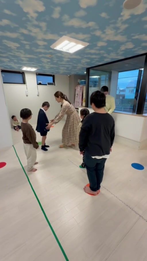 先生や仲間と輪になって、音楽に合わせて身体を動かす様子